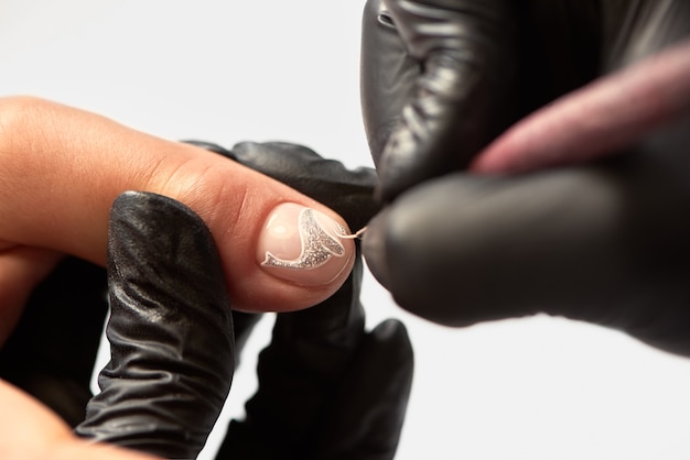 Manicurista maestro profesional trabajando en las uñas del cliente