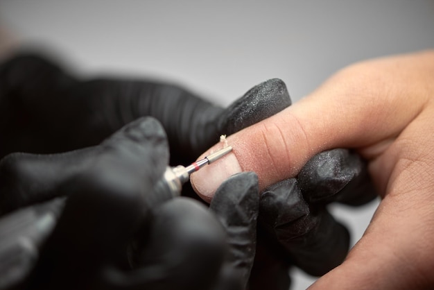 Manicurista maestro profesional trabajando en las uñas del cliente