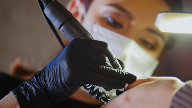 Manicurista en máscara médica haciendo manicura en salón de belleza, cerrar