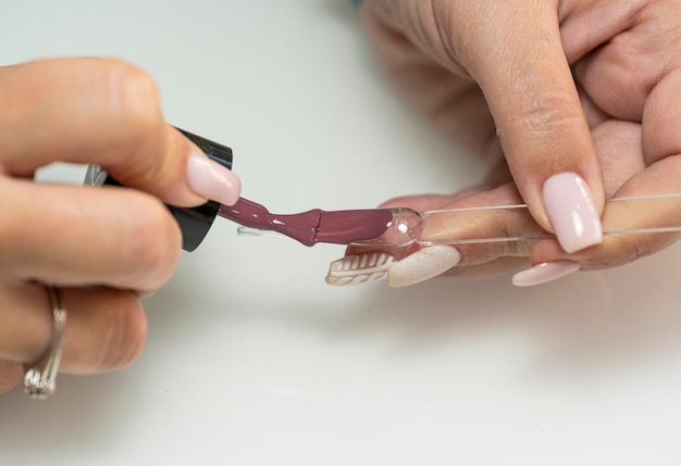 Manicurista mostrando un color de pintura de uñas a un cliente con una muestra de uñas