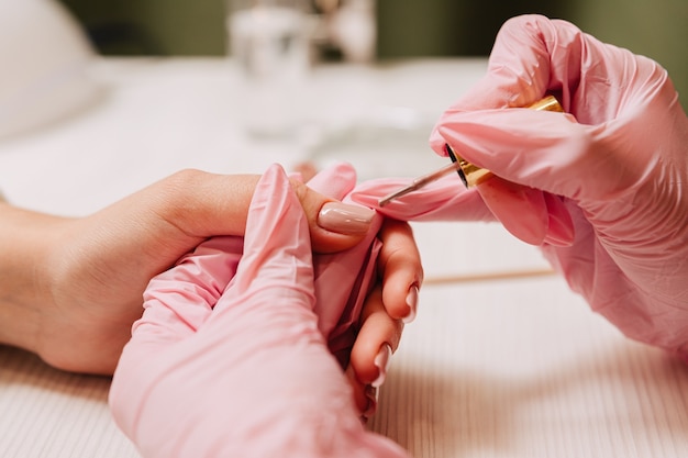 Manicurista pinta las uñas