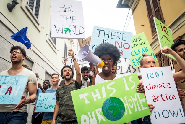 Manifestação pública na rua contra o aquecimento global e a poluição. grupo de pessoas multiétnicas protestando contra mudanças climáticas e problemas plásticos nos oceanos