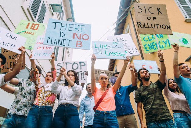 Manifestação pública na rua contra o aquecimento global e a poluição. Grupo de pessoas multiétnicas protestando contra mudanças climáticas e problemas plásticos nos oceanos