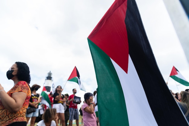 Manifestantes são vistos segurando a bandeira palestina durante um protesto na cidade de Salvador Bahia