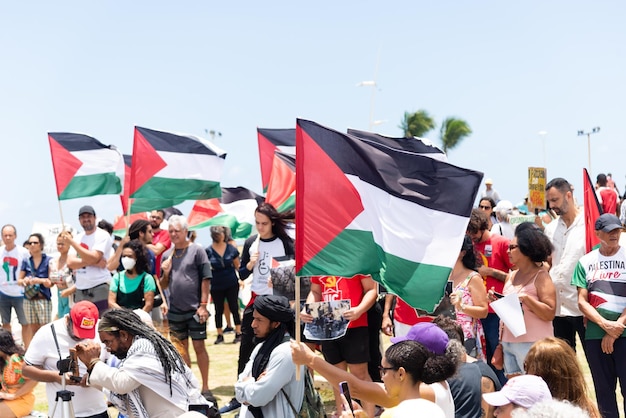 Manifestantes são vistos segurando a bandeira palestina durante um protesto