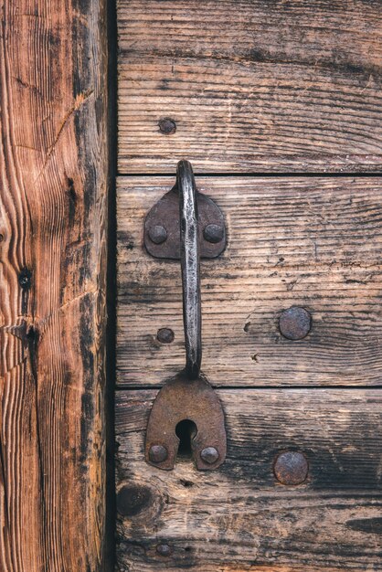 La manija metálica de la puerta está en una antigua casa de madera