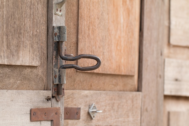 Foto manija oxidada vieja del metal en la puerta de madera