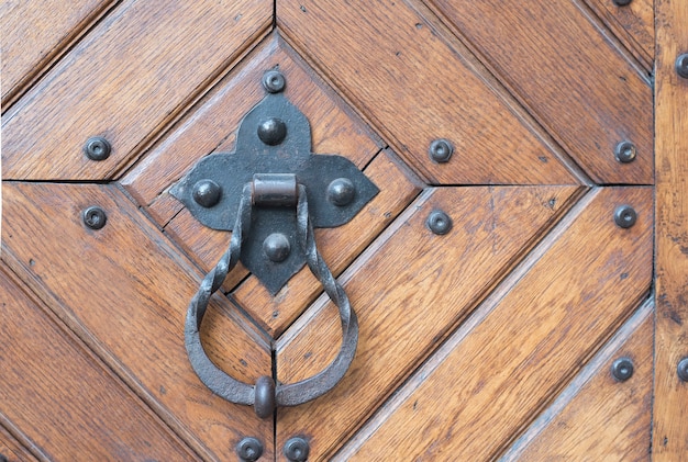 Foto manija de puerta de metal forjado con un anillo en una puerta de madera