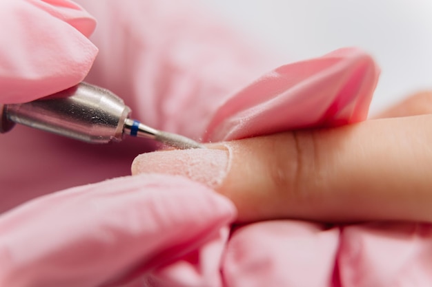Foto maniküre-prozess der meister poliert den nagel mit einer automatisierten bohrer-nagellackentferner-maschine