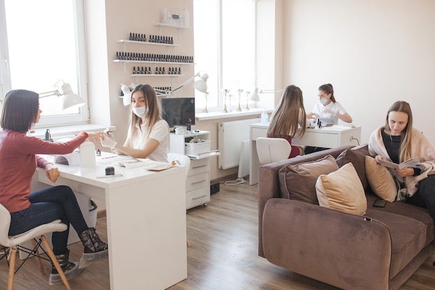 Manikürist macht eine Maniküre im Salon. Meister, der ihren Klienten betreut. Nagelpflege.