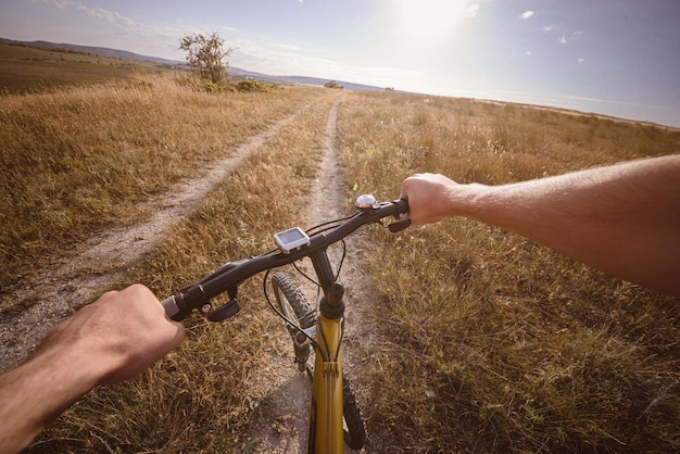 Manillar de bicicleta con lago y sol de fondo