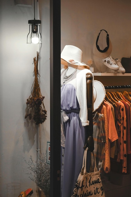 un maniquí con una camisa blanca y un sombrero está de pie frente a una tienda de ropa