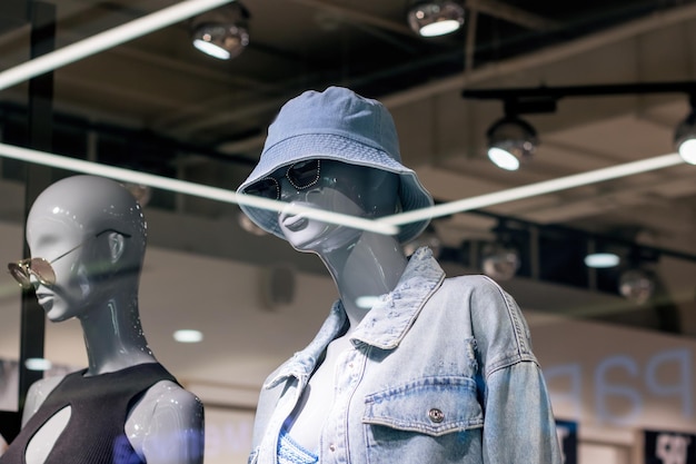 Maniquí con chaqueta de denim y sombrero de cubo como parte de una escultura