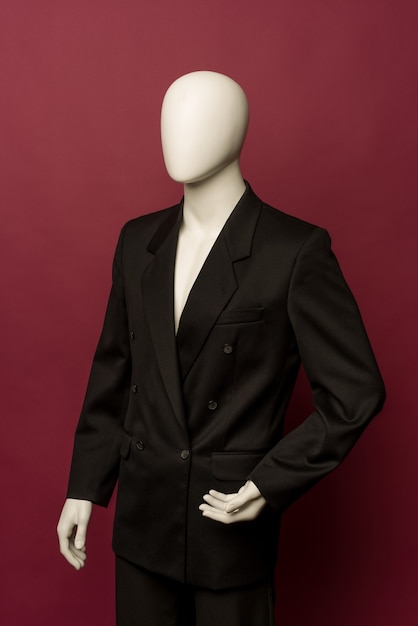 Maniquí de hombre blanco con traje negro sobre un rubí