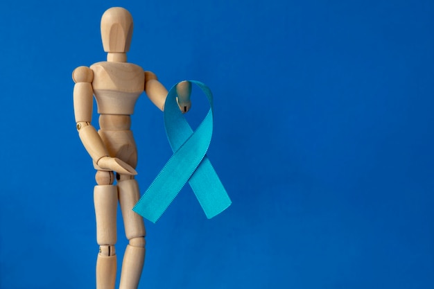 Maniquí de madera con cinta azul en la mano Noviembre azul Mes de la prevención del cáncer de próstata Salud de los hombres