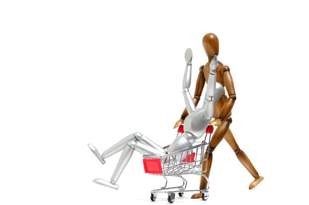 Maniquí marrón rueda maniquí blanco en un carrito de compras Concepto de alegría de ir al supermercado y de compras
