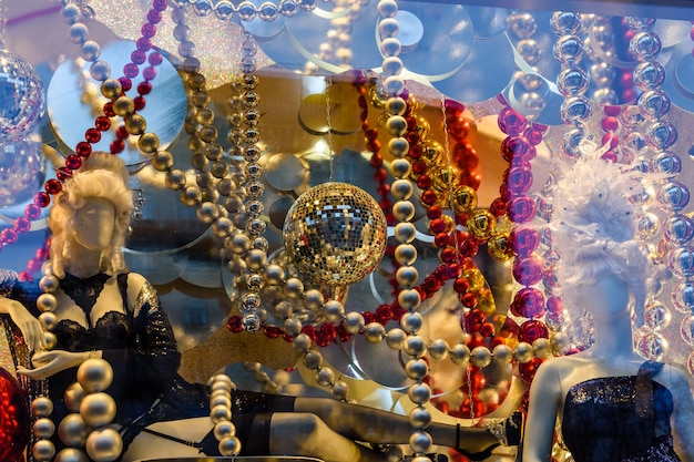 Maniqui de mujer vestida con lencería negra y diferentes adornos navideños en una vitrina