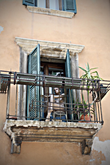 Maniquí sentado en el balcón del primer plano de la ciudad italiana.