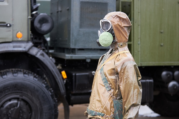 Foto maniquí vestido con traje de protección química y máscara de gas.