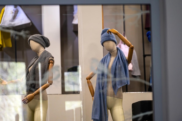 Maniquíes de la tienda de moda femenina con sombreros y bufandas detalles del enfoque selectivo de la ventana de la tienda