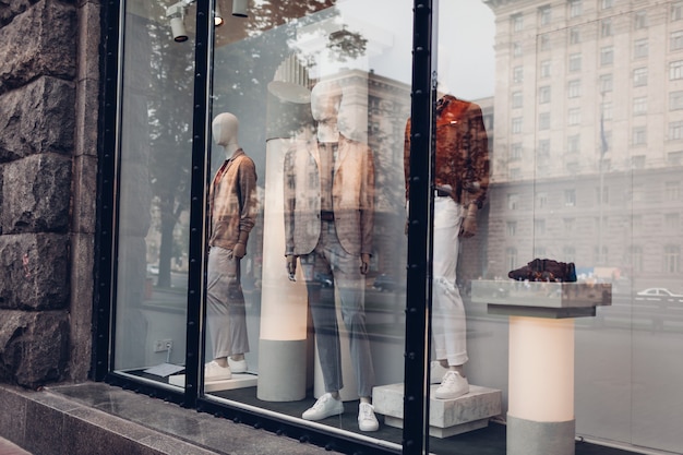 Foto maniquíes vestidos con trajes masculinos de otoño en el escaparate de una tienda en el centro de la ciudad. concepto de compras y ventas. viernes negro