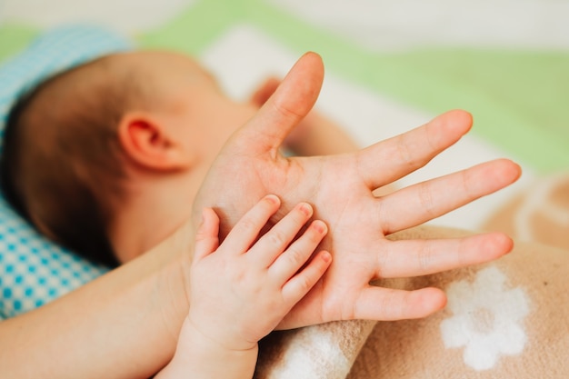 Foto la manita del bebé descansa sobre la mano del padre.