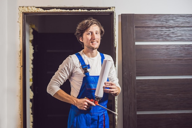 Manitas joven que instala la puerta con una espuma de montaje en una habitación.