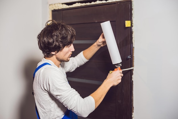 Manitas joven que instala la puerta con una espuma de montaje en una habitación.