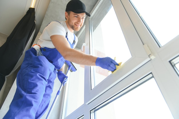 Manitas limpiando la ventana y sonriendo en una casa nueva