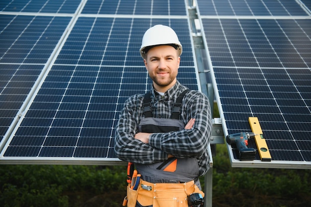 Un manitas de pie en la azotea con paneles solares y sonriendo a la cámara