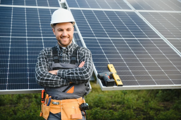 Un manitas de pie en la azotea con paneles solares y sonriendo a la cámara