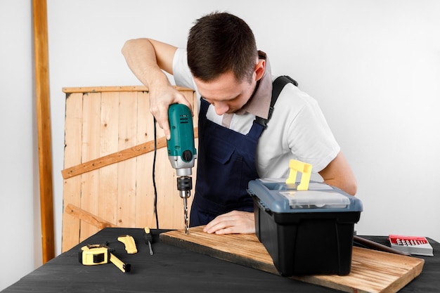 Manitas en uniforme azul trabaja con destornillador automático de electricidad