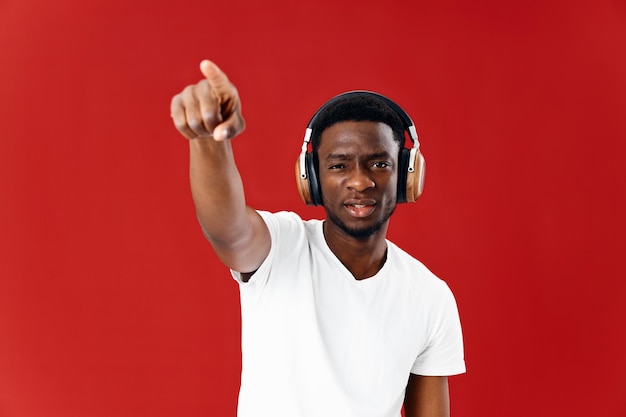 Mann afrikanischen Aussehens in weißem T-Shirt mit Studio-Kopfhörern in hoher Qualität