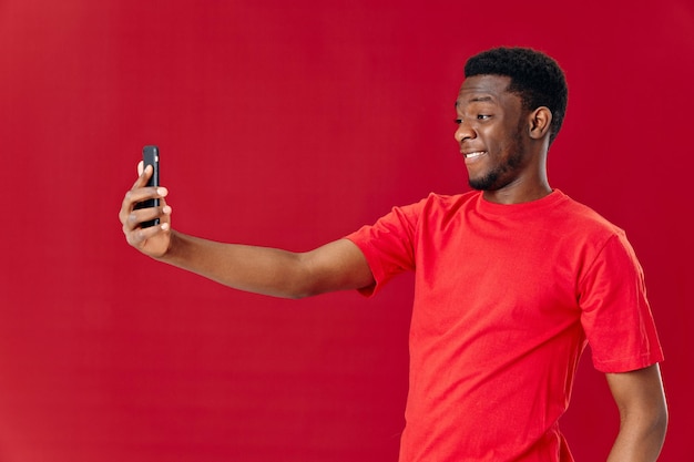 Mann afrikanisches Aussehen mit Telefon in der Hand Technologie Kommunikation Freude Hochwertige Foto