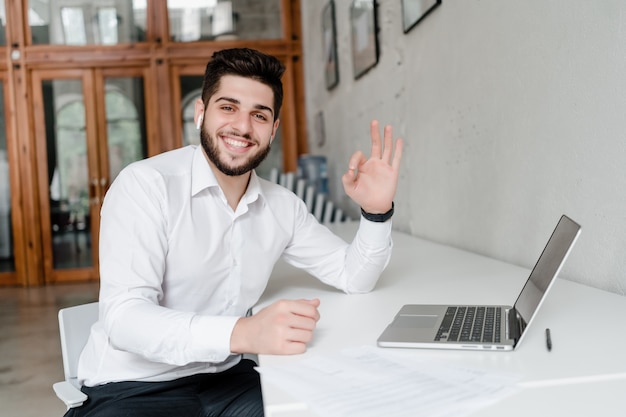 Mann am Arbeitsplatz mit Laptop im Büro