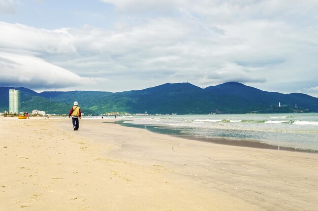 Mann am China Beach in Danang in Vietnam. Er wird auch Non Nuoc Beach genannt. Südchinesisches Meer und Marmorberge im Hintergrund.