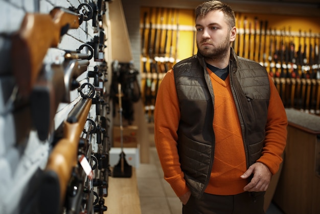 Mann am Schaufenster mit Gewehren