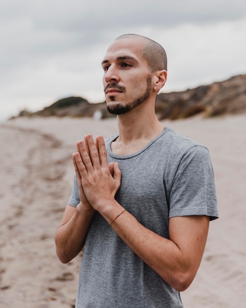 Foto mann am strand, der yoga-meditation praktiziert