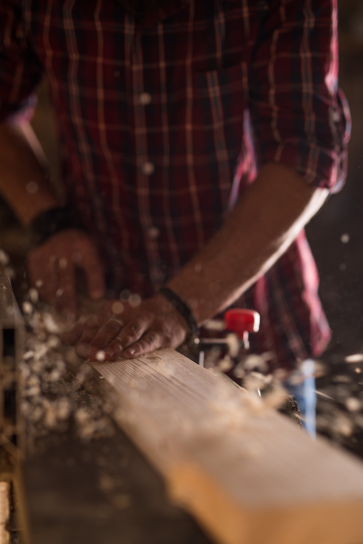 Foto mann arbeitet als tischler in seinem eigenen atelier holzbearbeitung