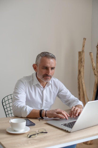 Mann arbeitet am Laptop sitzt am Tisch