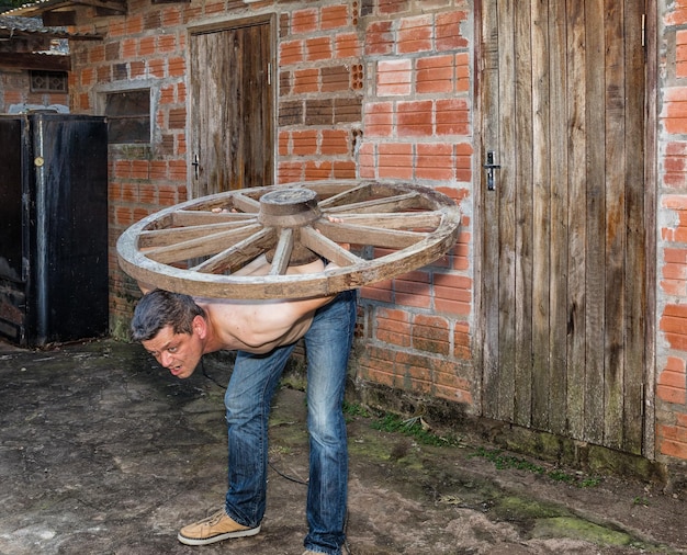 Foto mann arbeitet an holz gegen eine ziegelsteinmauer