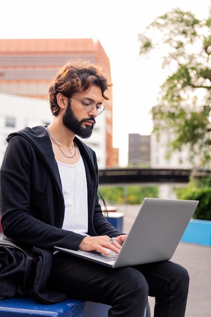 Mann arbeitet an seinem Laptop auf dem Universitätscampus