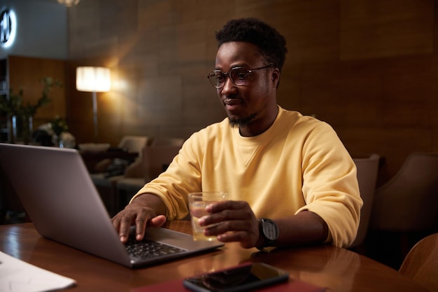 Mann arbeitet online am Laptop im Café