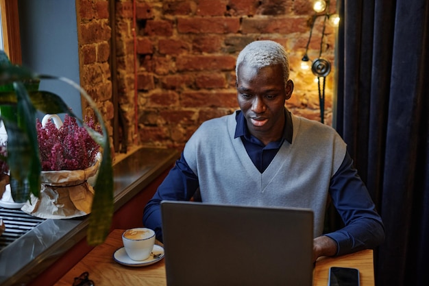 Mann arbeitet online im Café