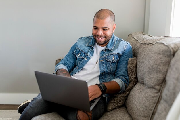 Mann arbeitet von zu Hause aus an seinem Laptop