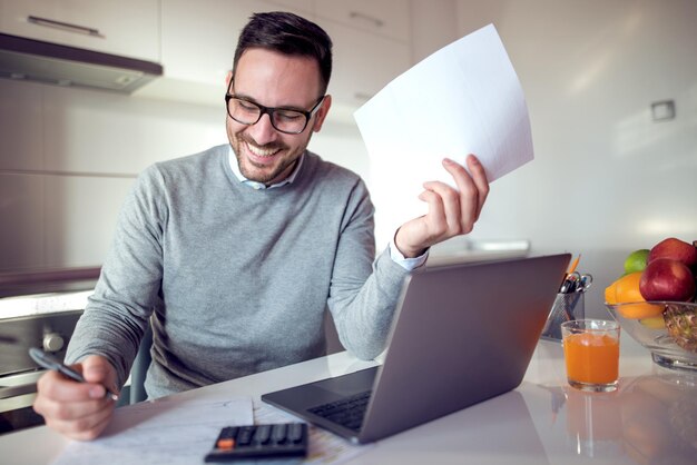 Mann arbeitet zu Hause am Laptop