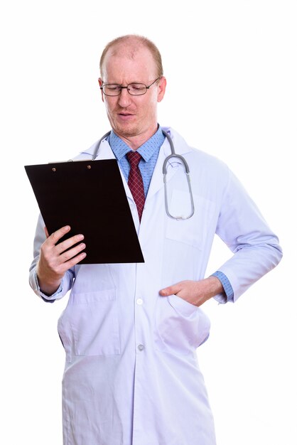 Mann Arzt stehend beim Lesen auf Zwischenablage isoliert auf weiß