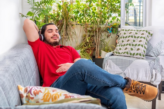 Mann atmet und ruht sich zu Hause auf einer Couch aus