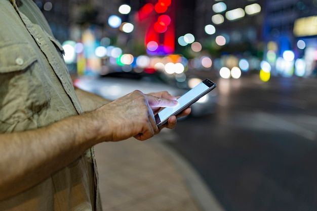 Mann auf der Straße mit Telefon in den Händen