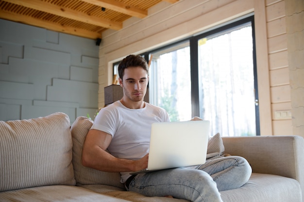 Mann auf Sofa mit Gadget